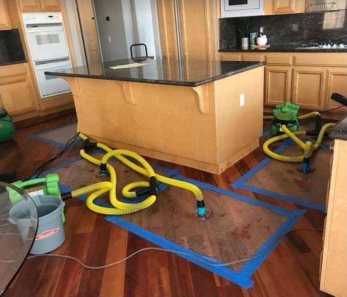 SERVPRO drying equipment and drying mat being used on water damaged floor